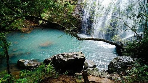 Banhista em uma cachoeira cristalina da região