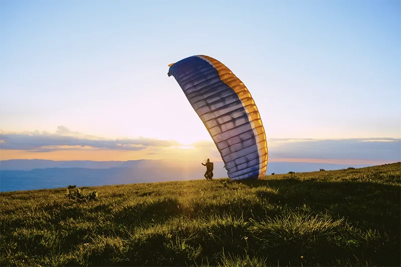 Pessoa saltando de parapente no Pico do Gavião