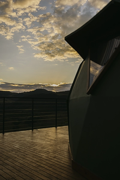 A tranquilidade contagiante do deck de madeira enquanto o sol se põe nas montanhas