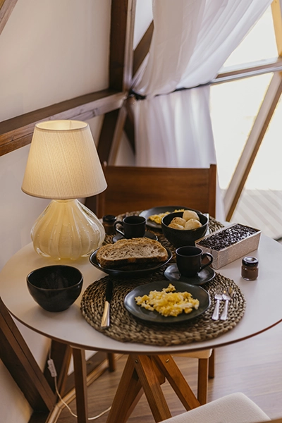 Mesa de madeira rústica no quarto de casal para um pequeno-almoço romântico no Domo