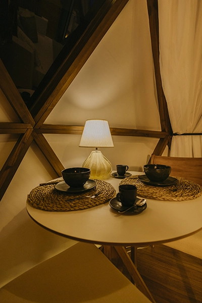 Mesa de cabeceira com luz suave de abajur e uma chávena de chá para relaxar antes de dormir