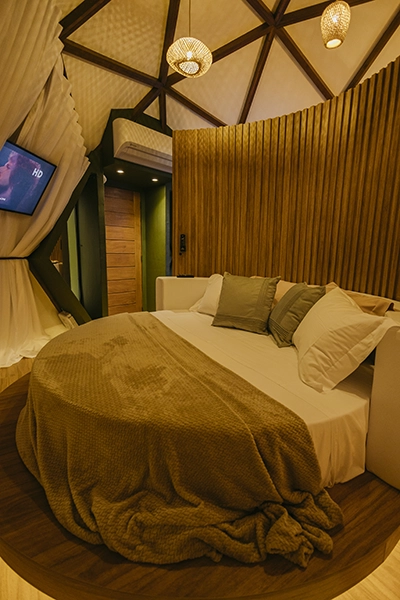 Detalhe da cama redonda com edredão macio e acabamentos de primeira qualidade