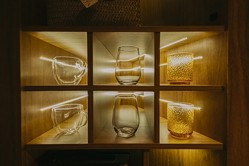 Copos de cristal dispostos na estante, perfeitos para brindar com os seus drinks favoritos