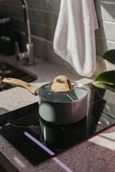 Moderno fogão de indução em vidro negro para preparar refeições gourmet